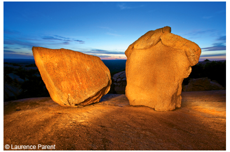 Two boulders on Enchanted Rock's main granite dome at dusk, painted by light.