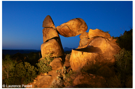 Stone arch created by balanced rock, at dusk with artificial lighting, Big Bend National Park, Grapevine Hills.