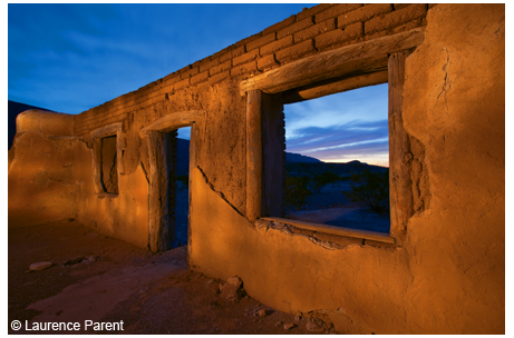 Old adobe house ruin at dusk, lit up with lights, in the Castolon area of Big Ben National Park.