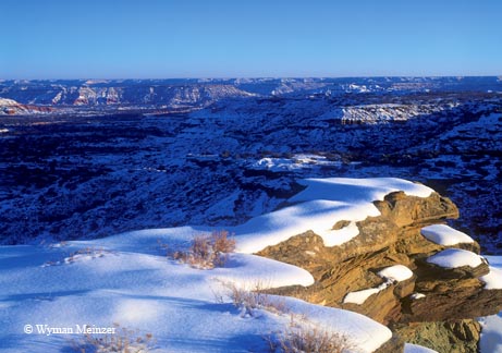 A winter snow catches the first light of the day at the rim of Palo Duro Canyon.