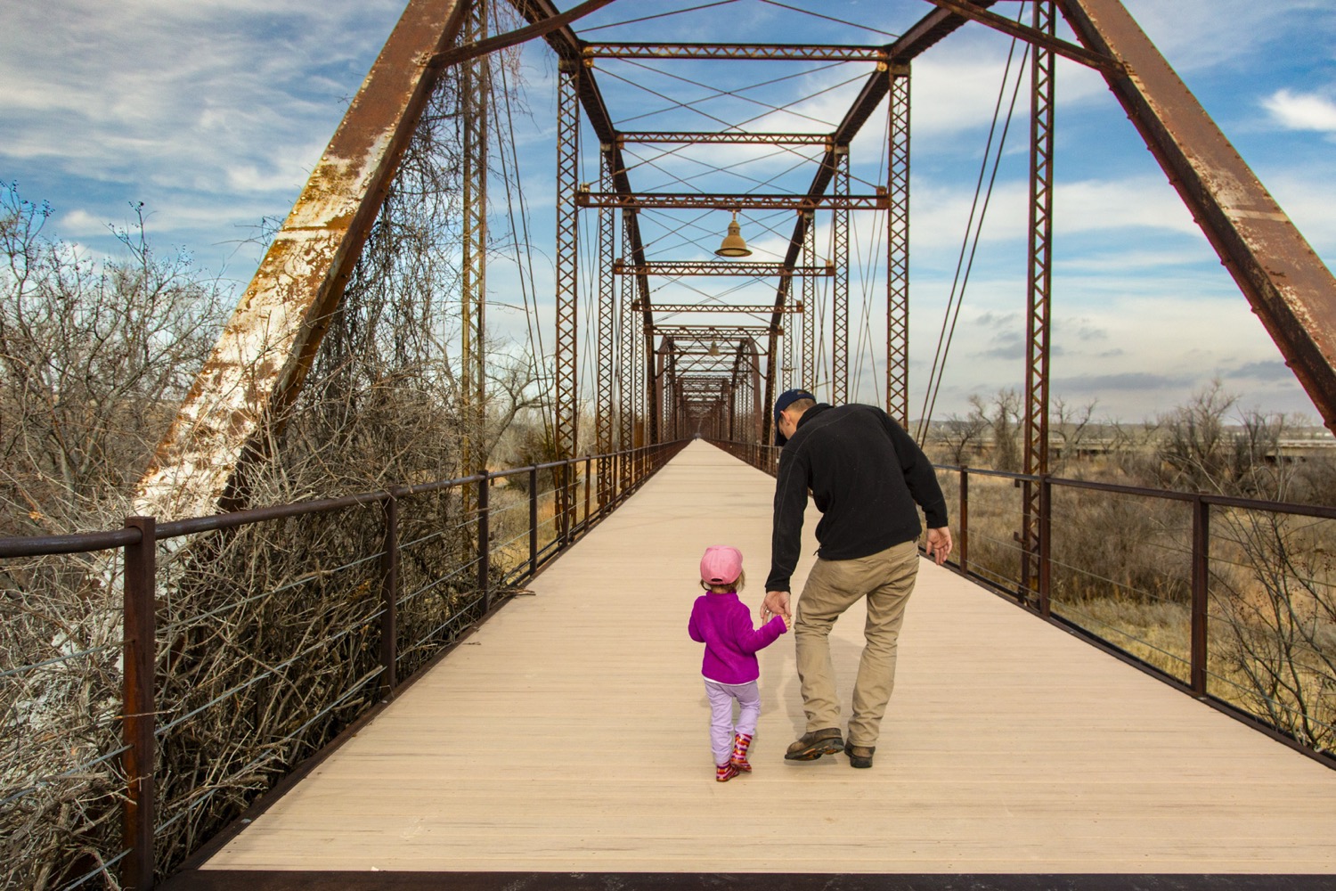 Dad and toddler walking over bridge