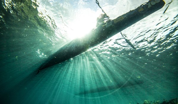 Shot of single paddler racing canoe from underwater on San Marcos River during Texas Water Safari