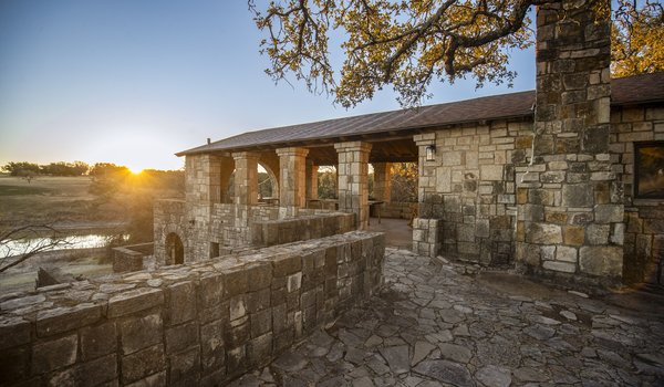 CCC Pavillion next to lake with sun setting behind it