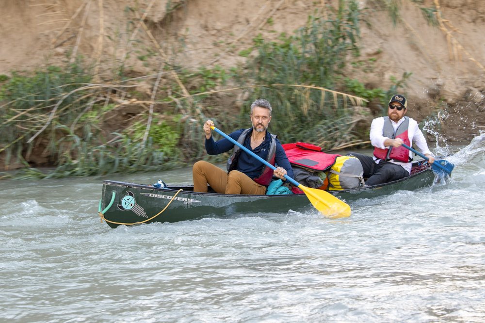 Two paddlers on a canoe navigating the swift waters of the lower canyons on the Rio Grande River