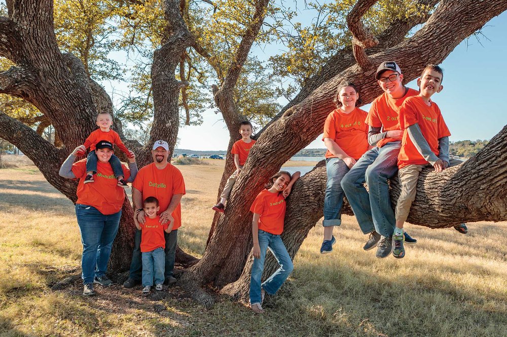 Roberto Family in tree with matching orange shirts.